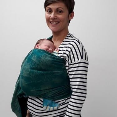 femme souriante portant son bébé sur le ventre