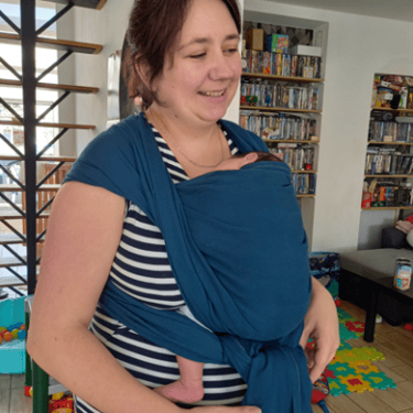 femme portant son bébé en écharpe bleue