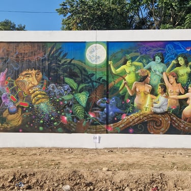 Surreal street art mural depicting shamanic rituals, celestial bodies, and mystical figures in a lush jungle.