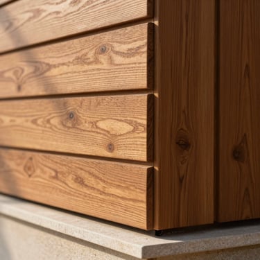 Extreme close-up of a teak timber cladding joint on a Sona Valley townhouse exterior wall, grain texture visible, warm afternoon sidelight casting fine shadow lines across the surface, stone sill below, no people