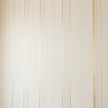 Elegant textured wallpaper with subtle metallic champagne gold vertical lines on ivory background, warm lighting, 35mm
