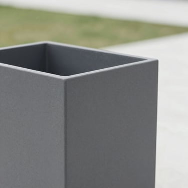 A square-cropped close-up of a matte charcoal-grey fibre planter showing its refined, textured surface under soft daylight.