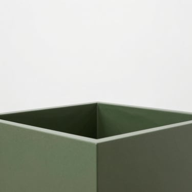 A square-cropped technical close-up of an integrated sub-irrigation reservoir inside a modern forest-green planter.