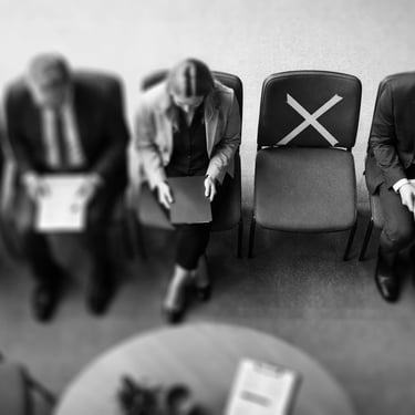 top-down view of a row of chairs with job aplicants, with one empty chair