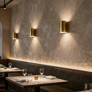 Fine dining restaurant interior, low-contrast diffused lighting, warm brass sconces illuminating textured plaster walls.