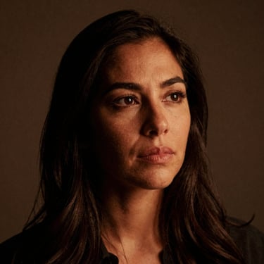 Portrait of a Latina woman in her 30s, thoughtful expression, subtle warm study room lighting, 35mm