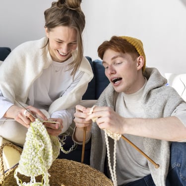 dos personas tejiendo con agujas