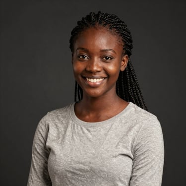 A smiling young woman working on her laptop in a cozy, bright home office.