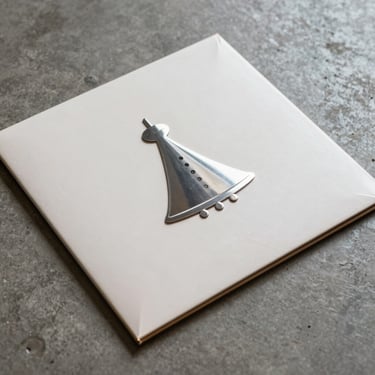 Square close-up of a physical vinyl record sleeve featuring a metallic 3D tokamat reactor icon, resting on a concrete floor.
