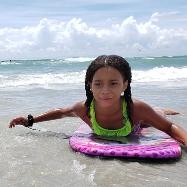 girl body surfing on beach