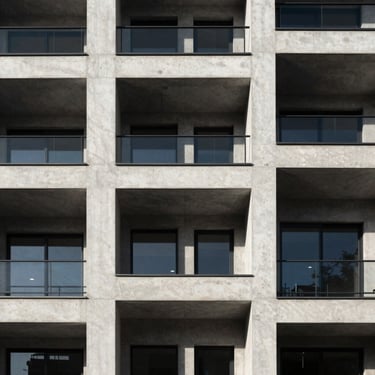 Straight-on geometric architectural elevation of a modern residential building facade, clean concrete lines, high-contrast natural light with deep shadows, stark composition.
