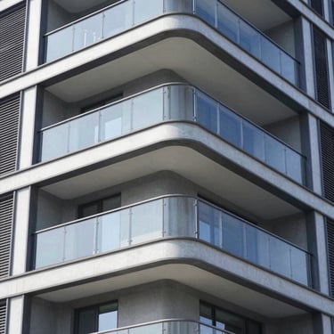 Close-up of modern folding glass balcony system installed on a luxury apartment balcony, bright daylight, crisp reflections