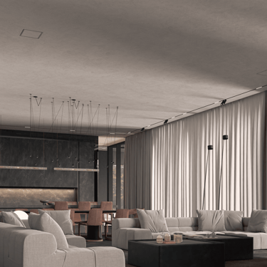 Open-plan living and dining area with ERGOVENT KVADRO diffusers flush-mounted in concrete ceiling above light gray sofas.