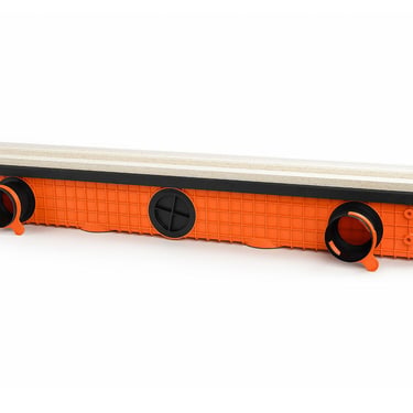 ERGOVENT LINEO PRO single-slot underside angled view showing orange plenum body with round duct inlets and gypsum face