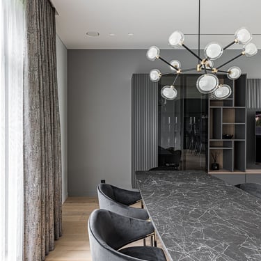 Luxury dining room with ERGOVENT RONDO invisible diffusers in white ceiling, black marble table and velvet chairs.