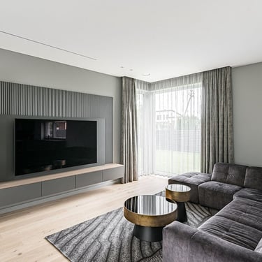 Modern living room with ERGOVENT RONDO invisible diffusers flush-mounted in white ceiling above gray sectional sofa.