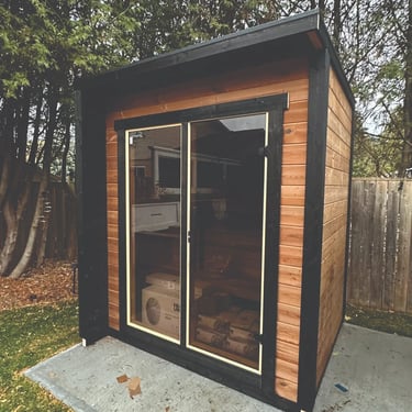 Modern square outdoor sauna with glass front and cedar siding built for Ontario homes