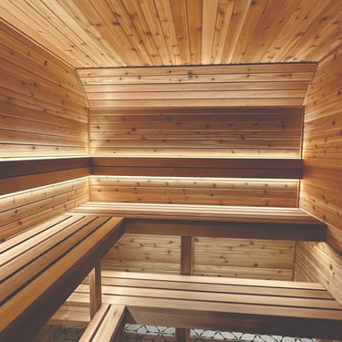 Cedar sauna interior with benches and warm lighting designed in Scandinavian style
