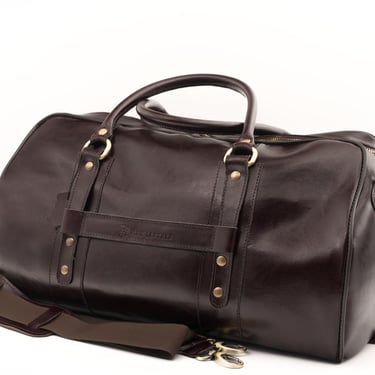 Geantă de voiaj din piele maro închis, fotografiată din față, centrată pe fundal alb.