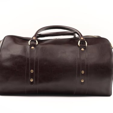 Geantă de voiaj din piele maro închis, fotografiată din față, centrată pe fundal alb.