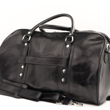 Geantă de voiaj din piele neagră, fotografiată din lateral, pe fundal alb.