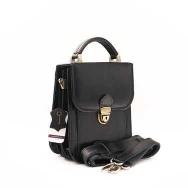 Geantă din piele neagră, fotografiată din față, pe fundal alb.