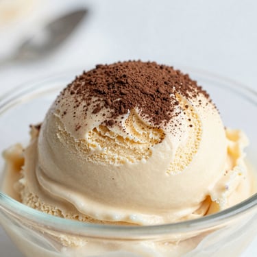 Espresso gelato with a dusting of cocoa powder, soft daylight, shallow depth of field.