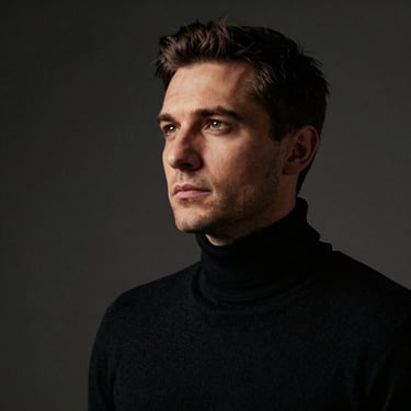 Professional portrait of a Lead Photographer, a Romanian man in a black turtleneck, looking into the distance with a sophisticated gaze, soft bronze-gold side lighting, cinematic dark mode aesthetic.