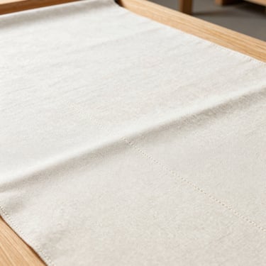 Close-up of heavy industrial canvas fabric with clean double-stitched seams, bright daylight