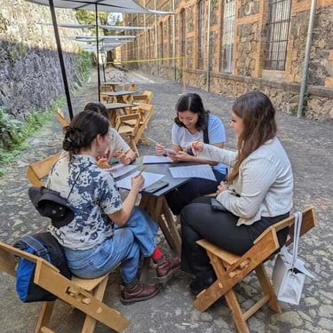 Alumnos conviviendo mientras estudian inglés, sentadas alrededor de una mesa.