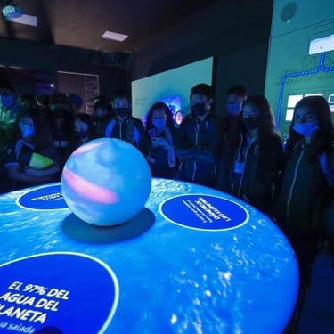 Alumnos en el museo del agua, alrededor de una mesa escuchando al exponente.