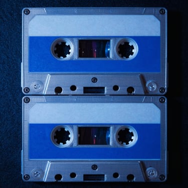 Album cover art with a vintage dual-cassette tape design under electric blue lighting