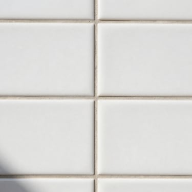 Extreme close-up of perfect tile grout lines, clean white subway tile, bright daylight, flawless alignment