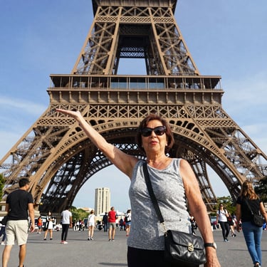 Smiling middle-aged woman enjoying a scenic Italian landscape during her trip.