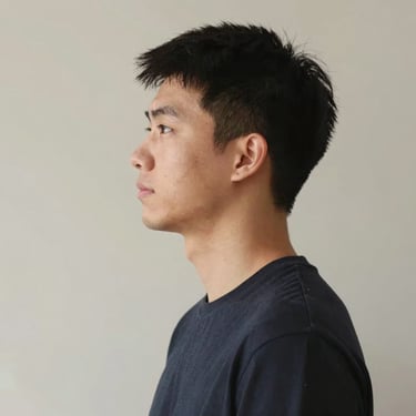 Smiling woman holding car keys standing next to her vehicle in a sunny parking lot.