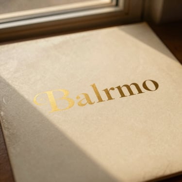 A close-up of a vintage vinyl record sleeve with warm gold typography, soft shadow, elegant layout