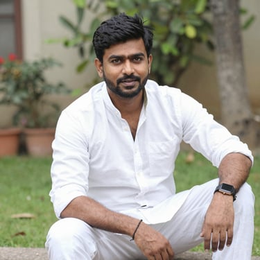 A man giving a thumbs-up with a bright, friendly smile in a casual setting.