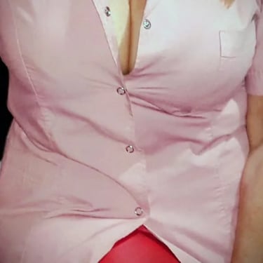 Ariadna vistiendo ambo profesional rosa escotado en su consultorio de masajes eróticos en Almagro.