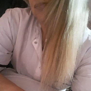 Retrato de Ariadna vistiendo chaqueta blanca profesional en su espacio de masajes en Almagro.