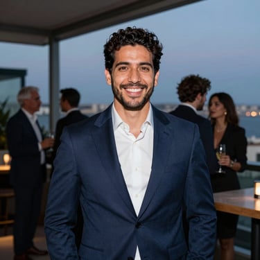 Portrait of a gentleman in a dark blue suit smiling during a corporate networking cocktail event in a modern rooftop lounge in Lisbon, twilight background.