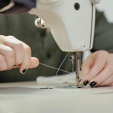 Insertando hilo en la Maquina de coser color blanco