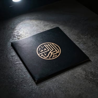 Minimalist vinyl record sleeve with geometric Arabic calligraphy, resting on a dark concrete surface under a single shaft of light