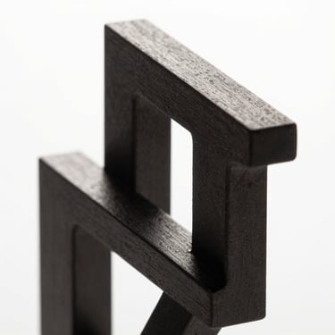 Abstract high-contrast 3D geometric structure, sharp metallic edges, dark charcoal and pure white lighting, studio background, macro shot, clean minimalist composition