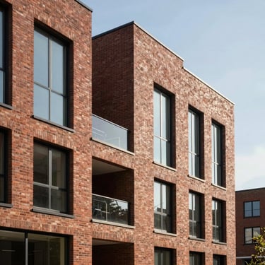 Modern multi-family brick building with large windows and clean geometric lines under clear daylight.