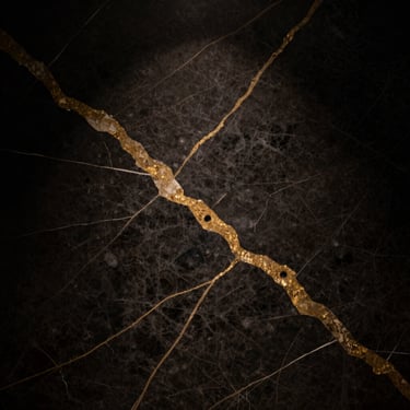 Extreme close-up of dark nero marquina marble texture with gold veins, dramatic low-key lighting