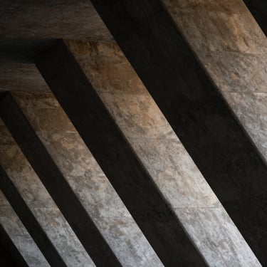 Abstract structural geometry of a modern concrete monolith, sharp architectural shafts of light