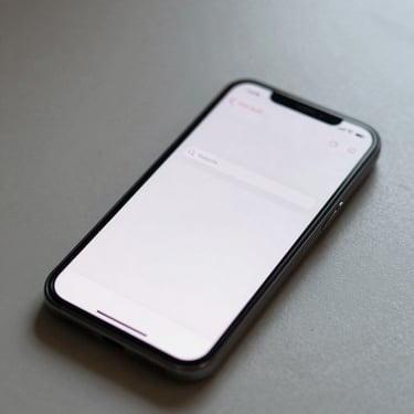 Overhead shot of an Android phone on a bare desk showing a note app with a single text entry field, cursor blinking, no toolbar visible, soft diffused window light, tight crop