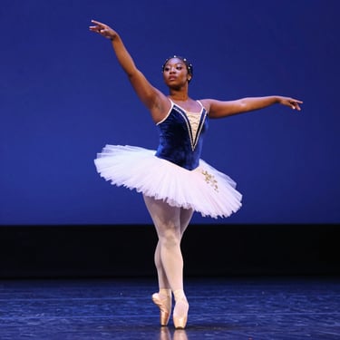 A group of young dancers rehearsing together in a bright studio.
