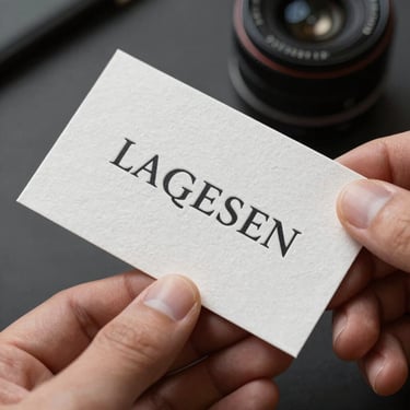 Uncoated business cards showing elegant typography pressed into heavy cotton stock, held by a hand.