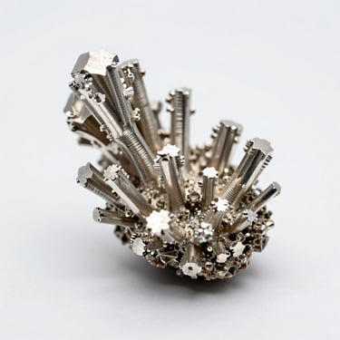 Extreme macro of a native silver wire crystal cluster on a white light table, controlled studio strobe revealing metallic luster and dendritic growth structure, neutral white negative space surrounding the specimen